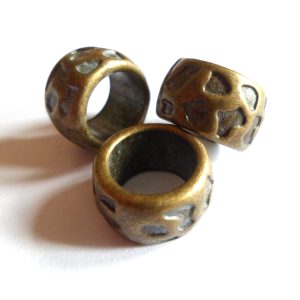 Bronskleurige metalen kraal voor rond een dreadlock. Deze kraal heeft een groot gat, waardoor hij geschikt is voor dikke dreads, maar ook als baardkraal.